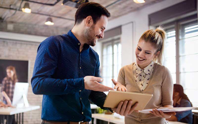 Two employees smiling at another