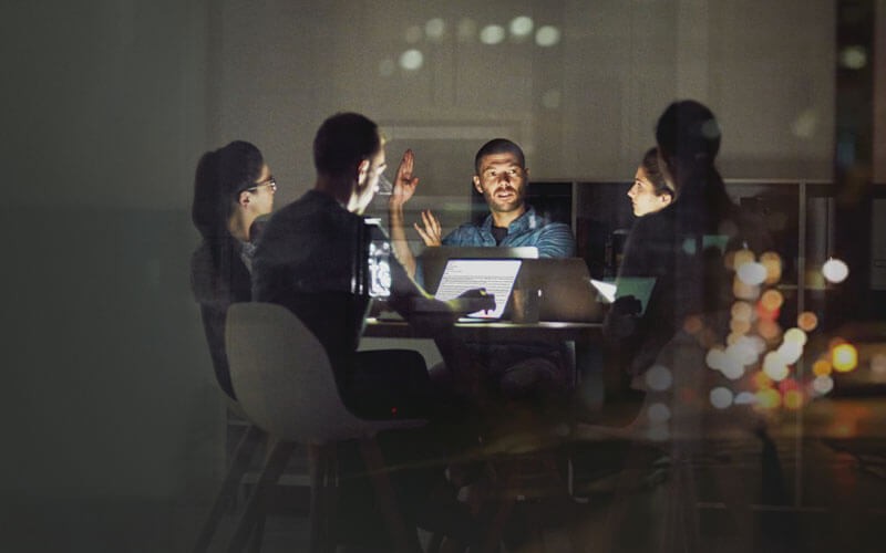 Group of people working in a darkened office