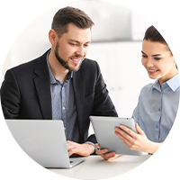 Man with tablet looks to where woman is pointing 