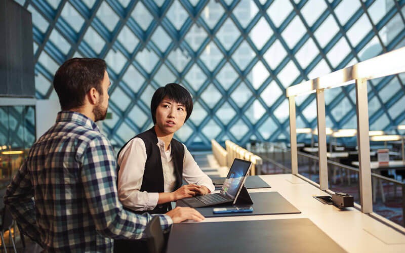 Woman and man collaborating with Microsoft Surface