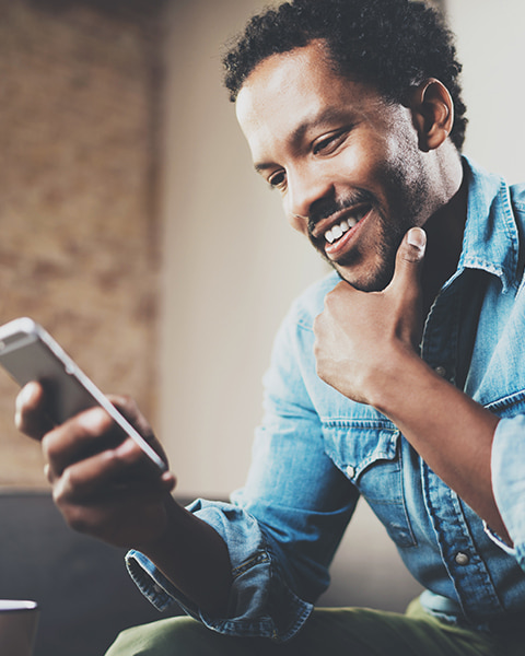 Bearded man smiling looking down at his phone