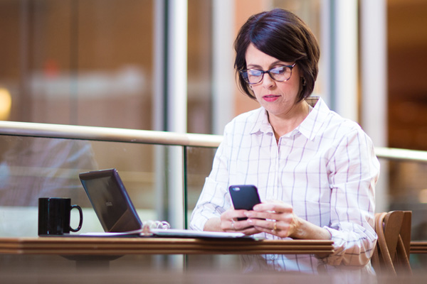 Women on her phone working remotely using the government mobility service offered by Insight