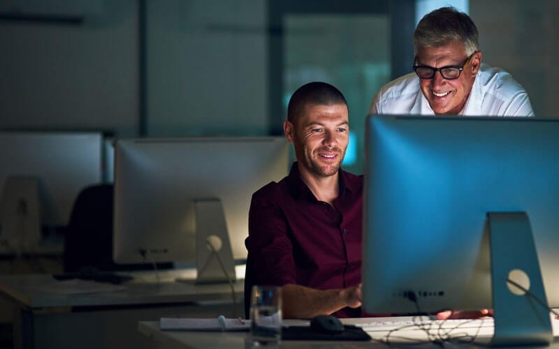 Two men working together at desk