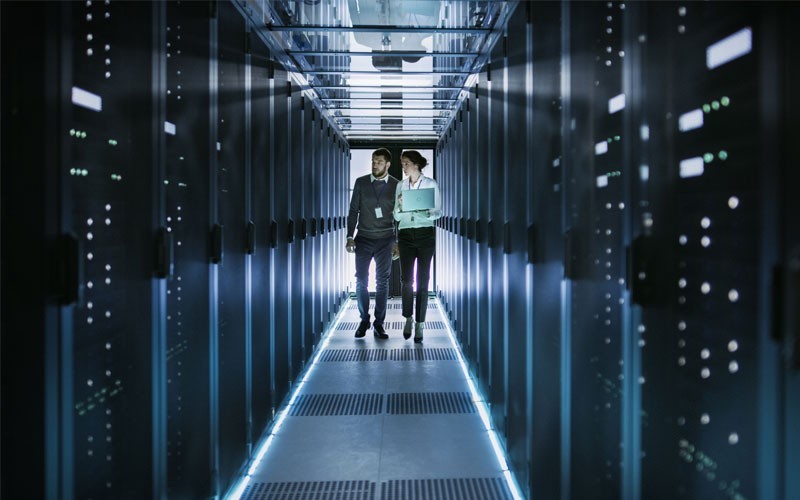 Two technicians walking through a data centre