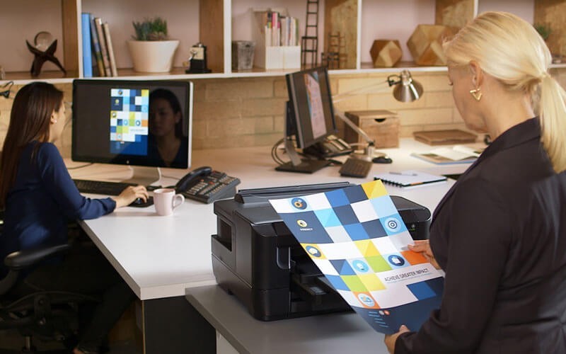 Epson commercial print solutions Business woman in office grabbing print design from printer