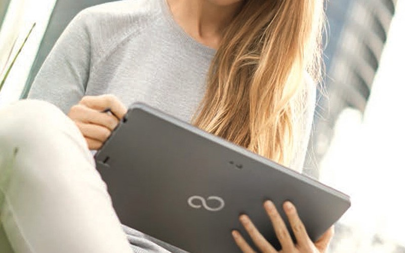 Digitisation is rapidly changing how we interact Student holding a Fujitsu tablet