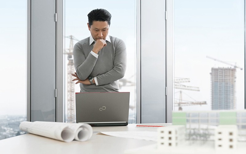 Reduce cost and drive efficacy with Fujistu Man staring at a laptop screen