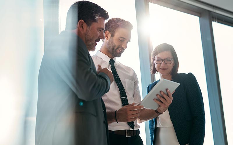 Custom-designed service and support programs for technology businesses Woman and male discussing over desktop device