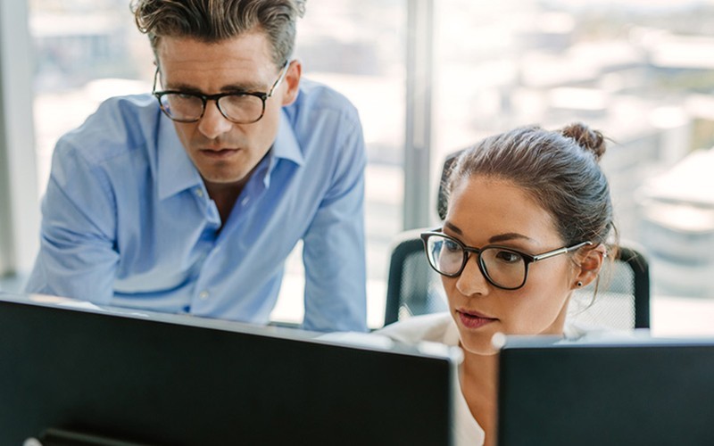 Two colleagues sharing a laptop in a meeting