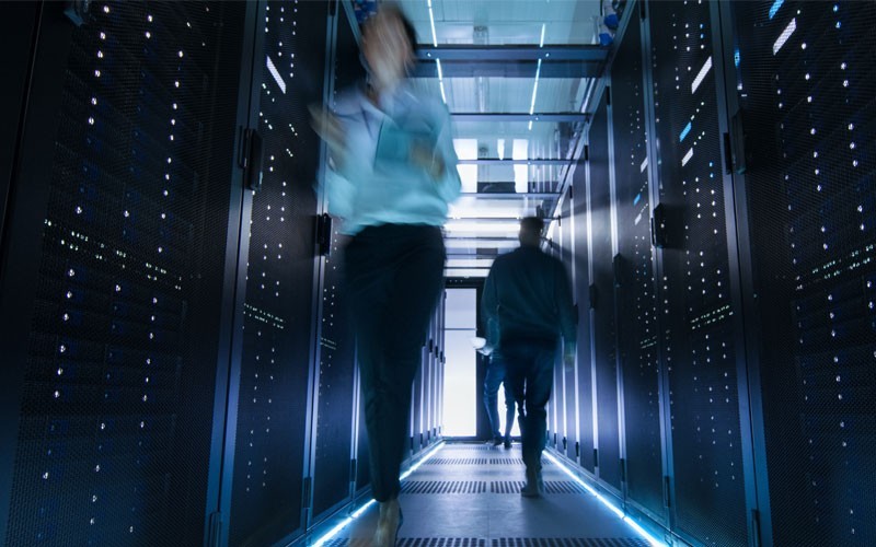 Two people walking through data centre