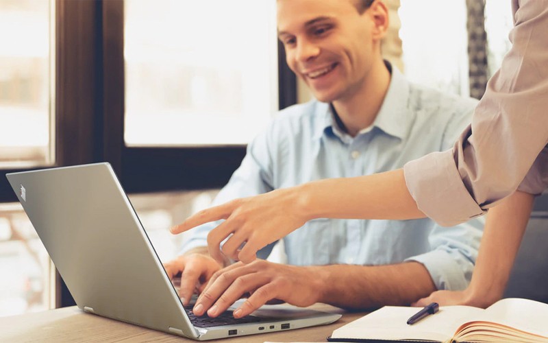 Man using a Lenovo laptop with a colleague