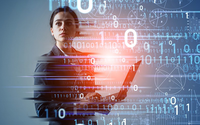woman with laptop surrounded by binary code