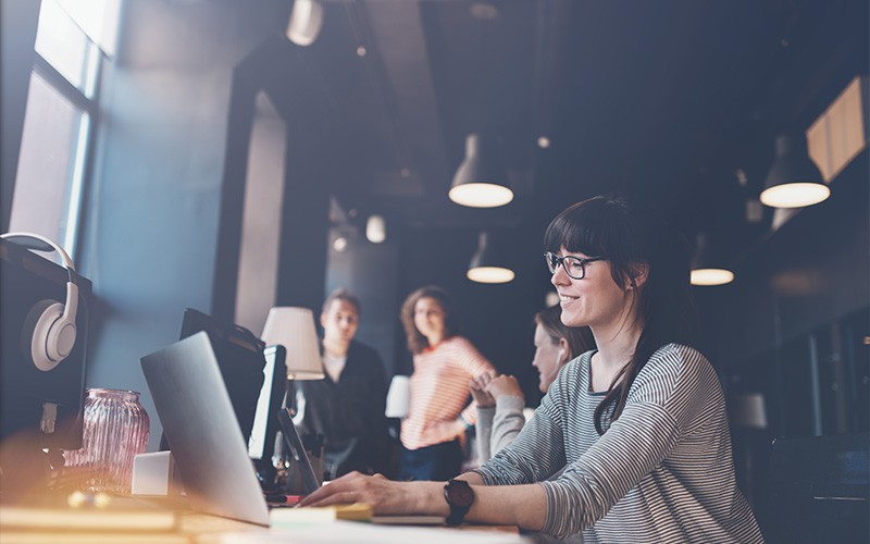 Close the IT monitoring visibility gap Woman smiling while using laptop
