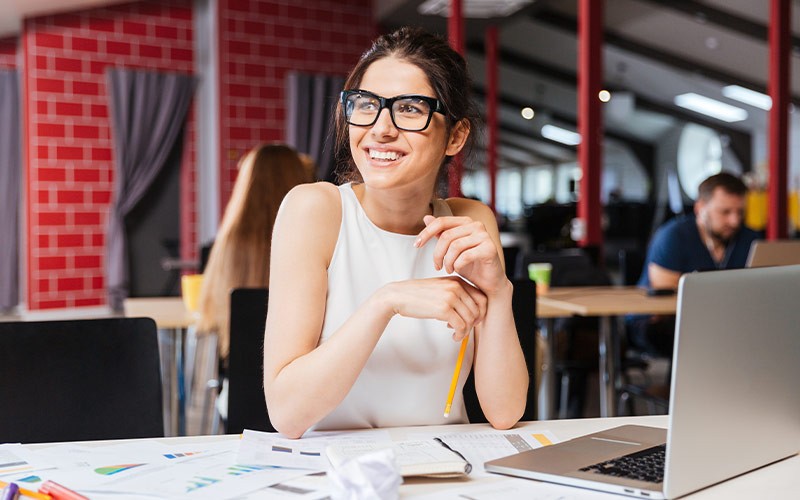 Aternity automatically generates a baseline for every application Woman smiling in front of a laptop while looking at a colleague